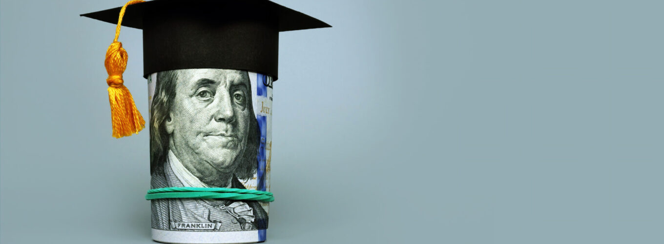 Loan or savings for college. Graduation cap and roll of dollars.
