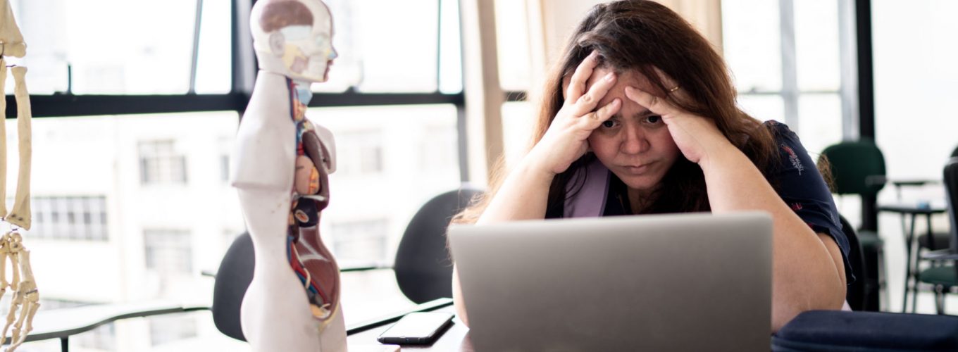 Displeased teacher working using laptop in the classroom