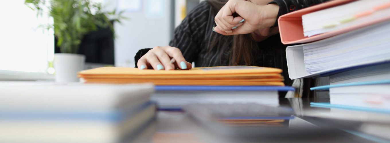 Tired woman sleeping on paper documents in office. Bureaucracy at work concept