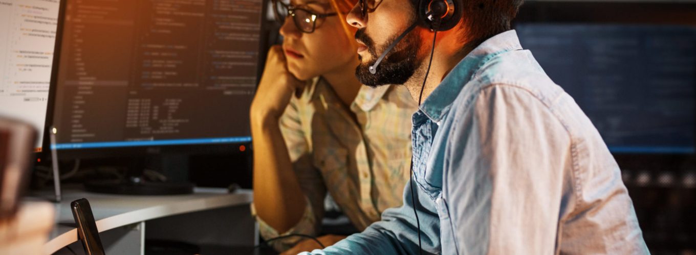 Two programmers working on new project.They working late at night at the office.