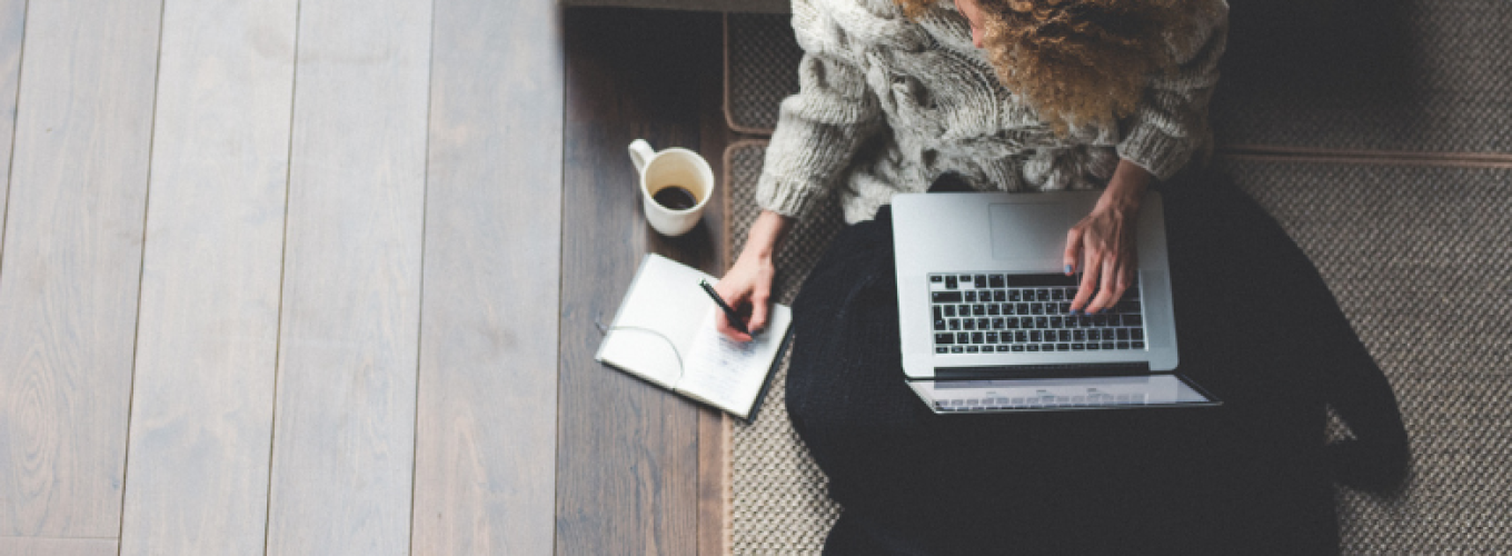 Curly-haired woman studying with a laptop