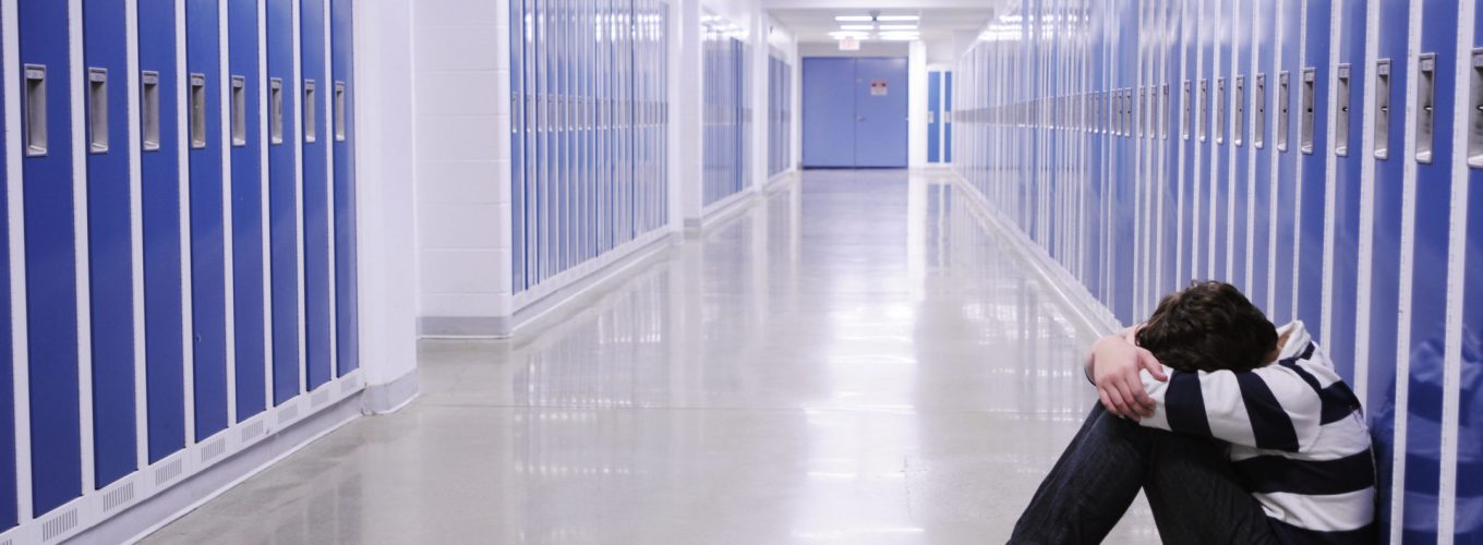 Depressed Boy in School Hallway