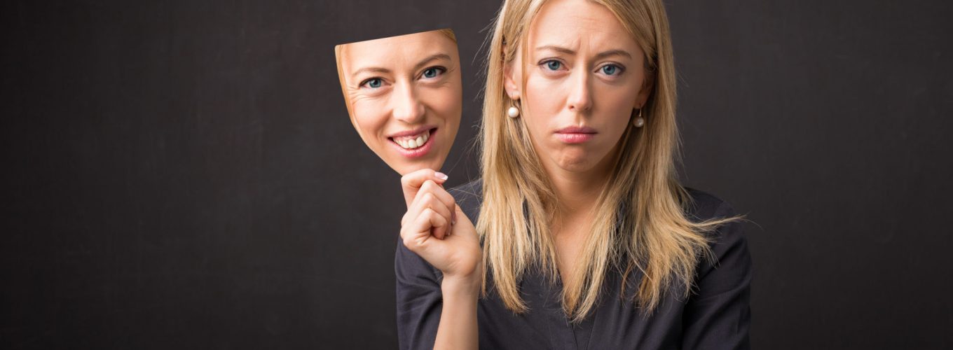 Woman holding mask of her happy face