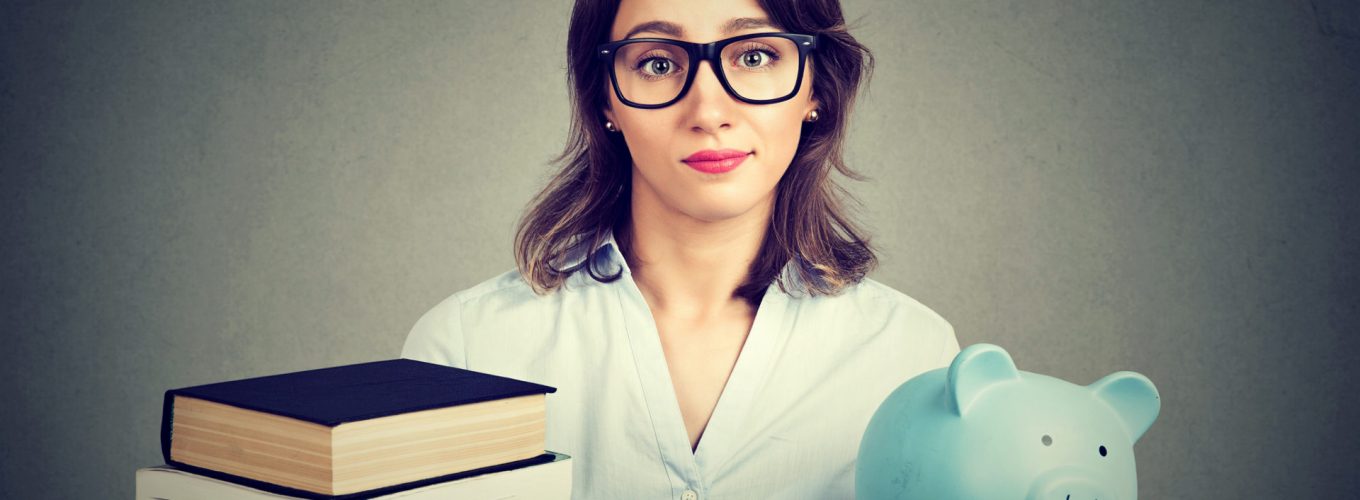 Young woman with stack pile of books and piggy bank full of debt rethinking future career path